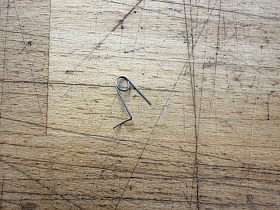 Anti reversal latch spring